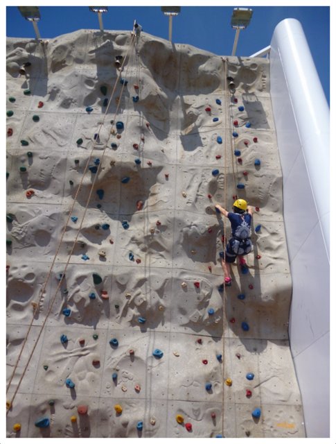 YQ climbs a rock climbing wall